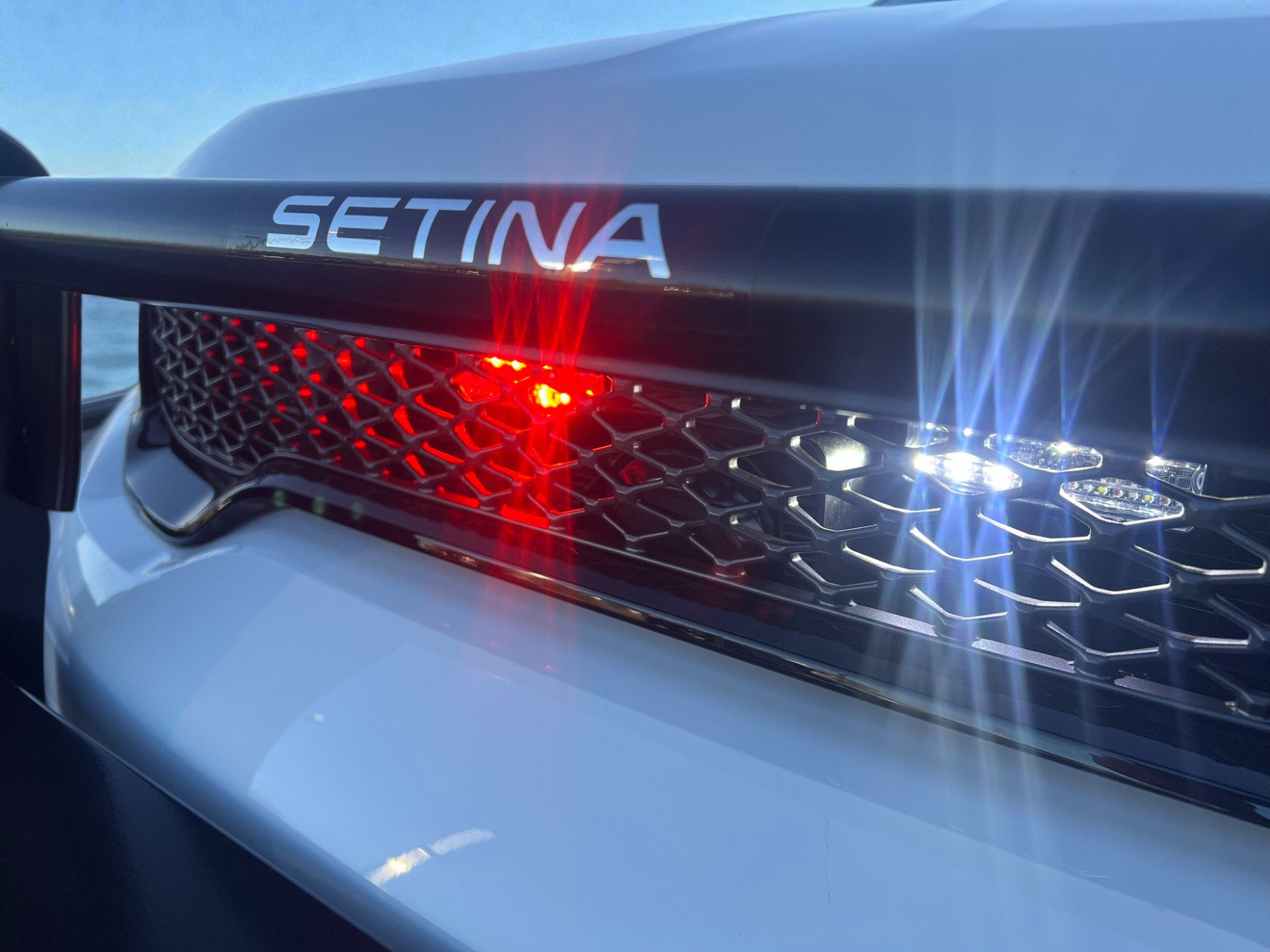 Close-up of a police car's SETINA light bar glowing red and blue.