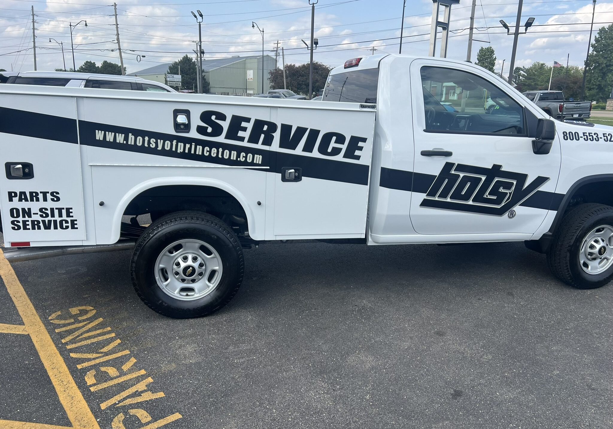 Service truck parked in a lot with company branding.
