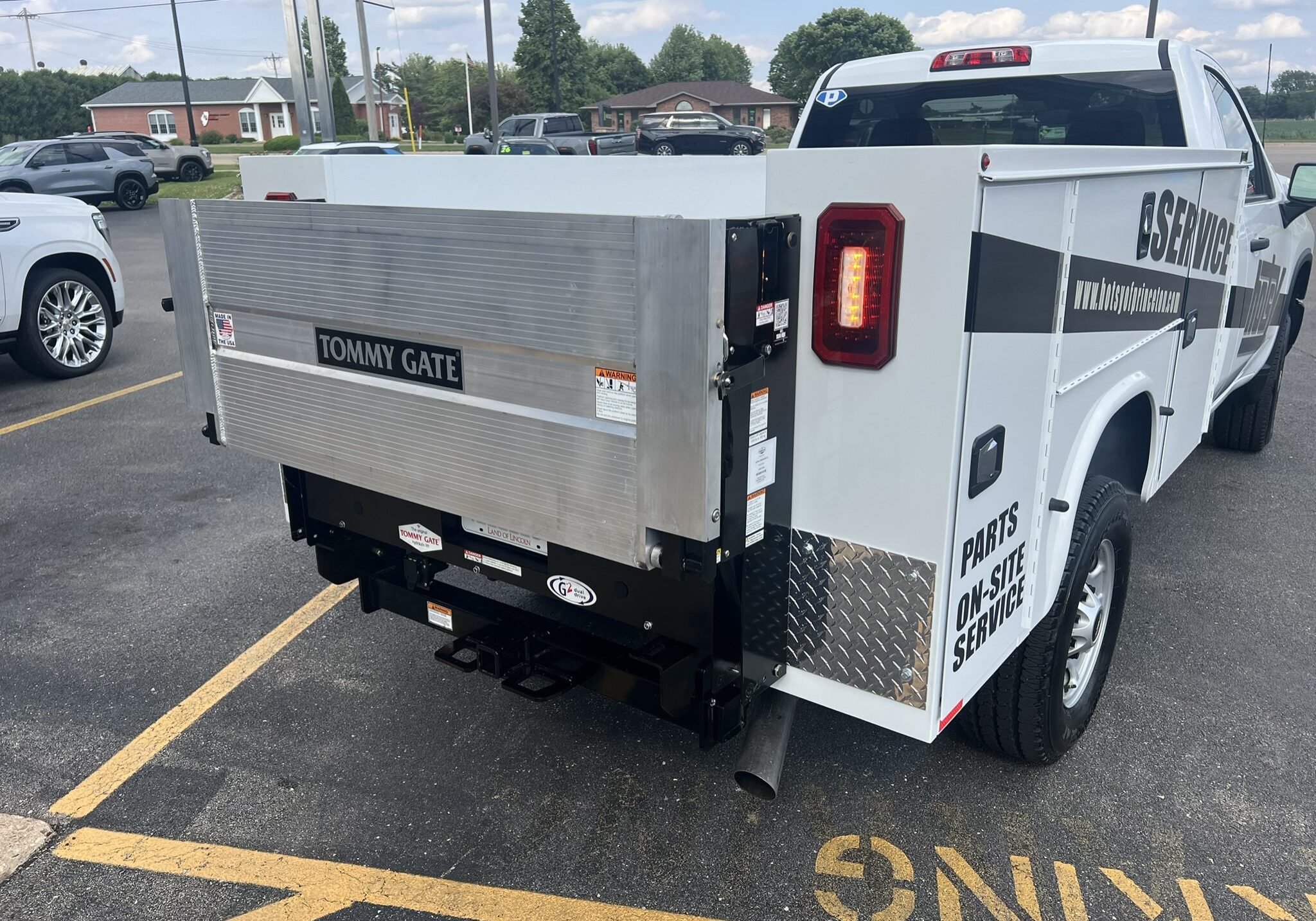 Aluminum utility truck bed with storage compartments and a lift gate.