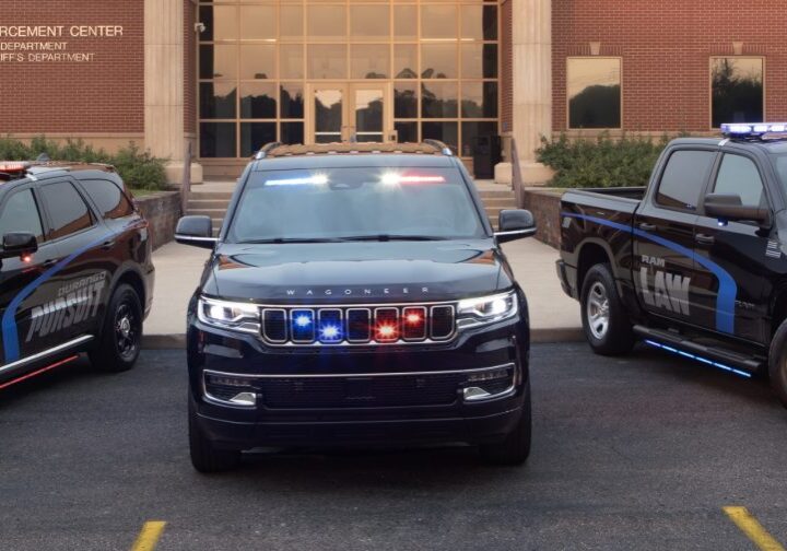 Police SUV with flashing lights parked in front of a building.