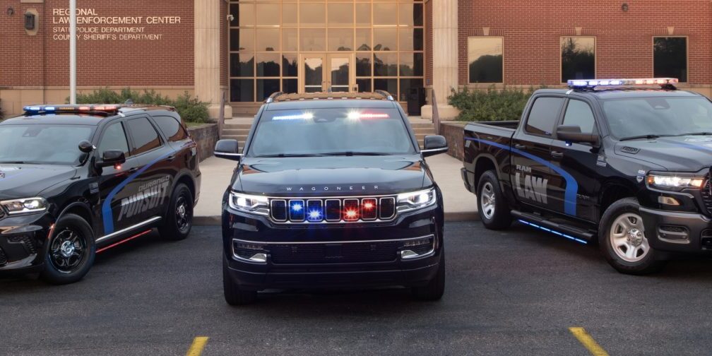 Police SUV with flashing lights parked in front of a building.